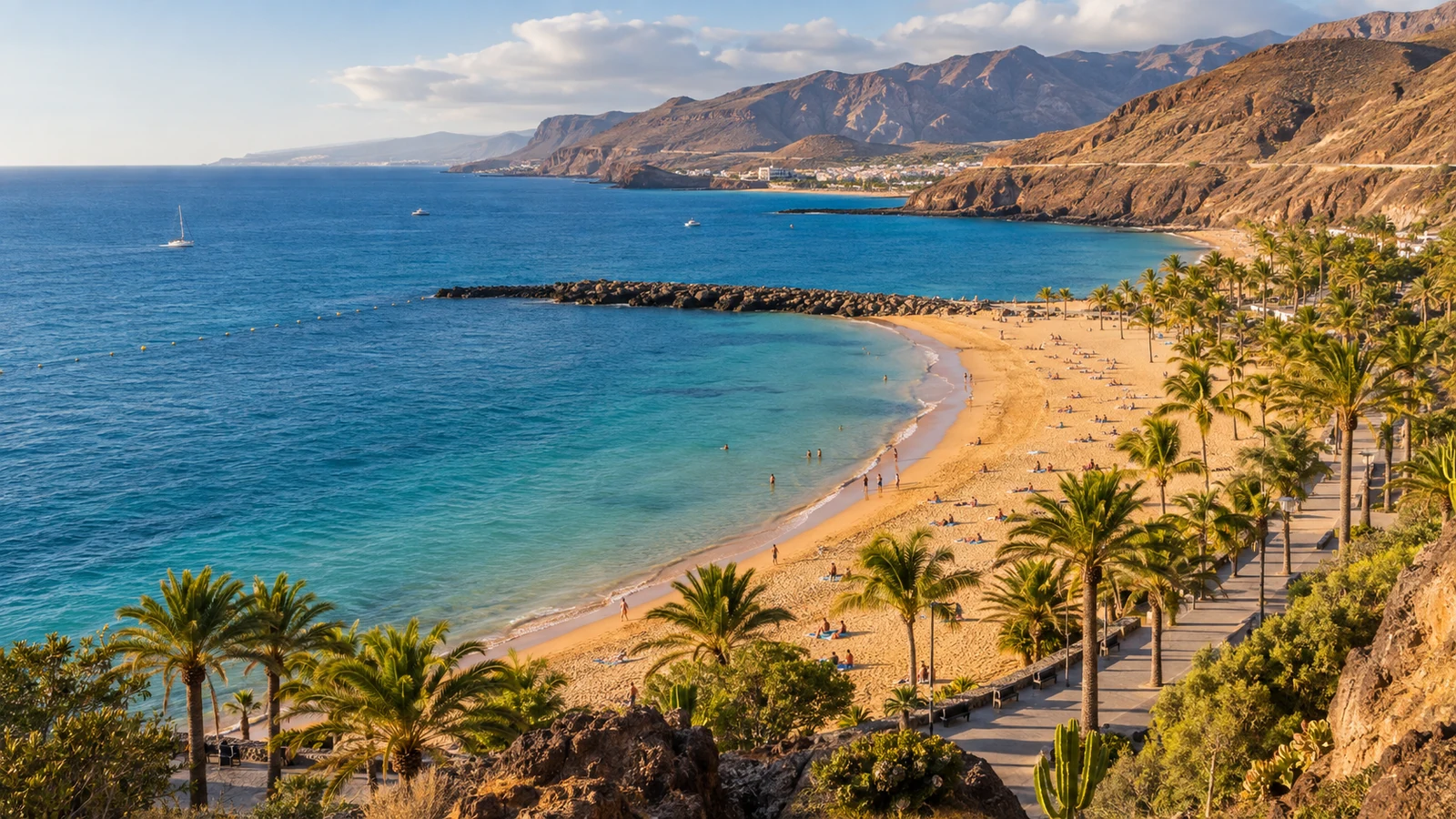 Golden beach, palm-lined promenade and volcanic hills beside the Atlantic in Tenerife
