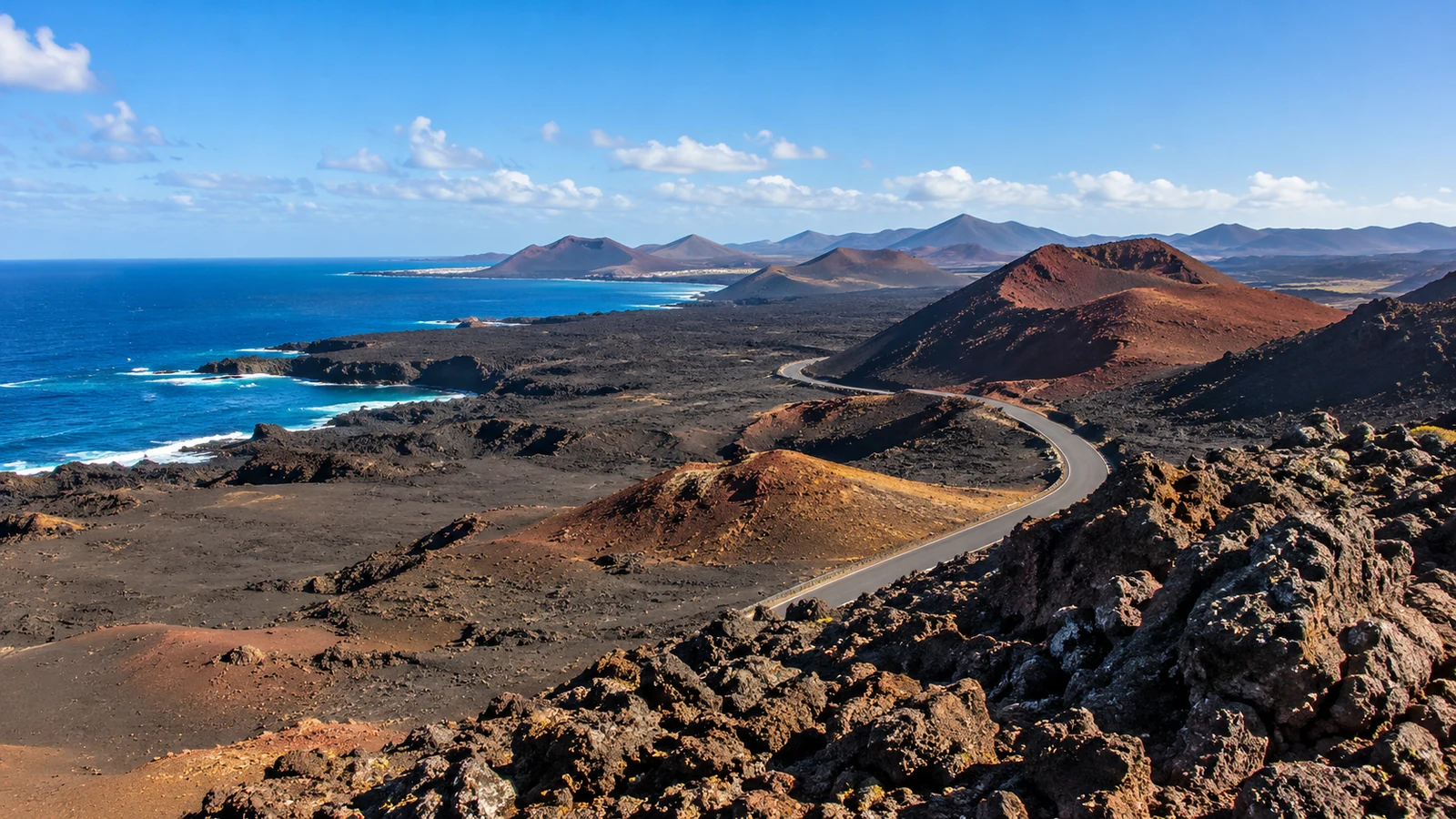 Winding road through volcanic hills beside the eastern Canary Islands coast